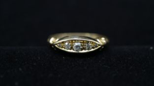 An Edwardian 18 carat yellow gold and diamond five stone ring, set with four round old cut