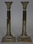 A pair of sterling silver Corinthian column candlesticks, one engraved with dedication.