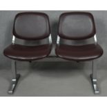 A pair of vintage waiting room or cinema seats in vinyl upholstery on brushed metal frame marked