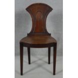 A late Georgian mahogany hall chair with shield shaped back above panel seat on square tapering