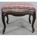 A 19th century mahogany footstool in tapestry upholstery on cabriole supports terminating in brass