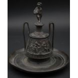 An antique bronze inkwell in the form of a two handled Grecian urn with a human form finial and