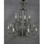 A metal framed sixteen branch chandelier with twelve light fittings in two tiers all with cut