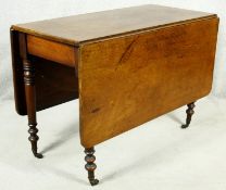 A 19th century mahogany drop flap dining table on turned tapering supports terminating in brass