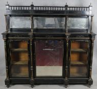 A late Victorian ebonised mirror backed credenza with allover incised gilt carving the bevelled