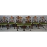 A set of eight Georgian style mahogany dining chairs with carved shield backs on tapering square