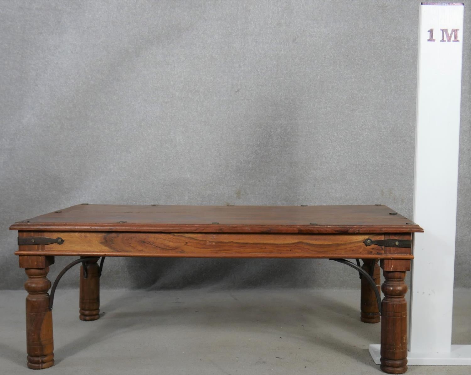 An Indian teak and metal bound coffee table on circular section supports. H.41 L.110 D.60cm - Image 4 of 4