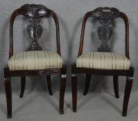 A pair of late 19th century Continental mahogany hooped back dining chairs with carved splats on