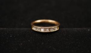 An 18 carat yellow gold and diamond half eternity ring. Set with six square princess cut diamonds