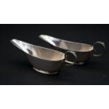 A pair of Victorian sterling silver sauce boats by Williams Ltd. With foliate design handles and