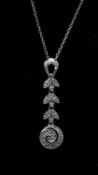 A 14 carat white gold and diamond set articulated foliate design pendant and chain. The pendant is