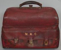 A lockable red leather travelling men's vanity case. Contains ivory glove stretchers, silver
