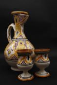 An Islamic glazed hand painted terracotta ewer with stylised foliate and floral design with two