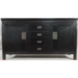 A black lacquered Chinese style sideboard with central drawers flanked by cupboards on block