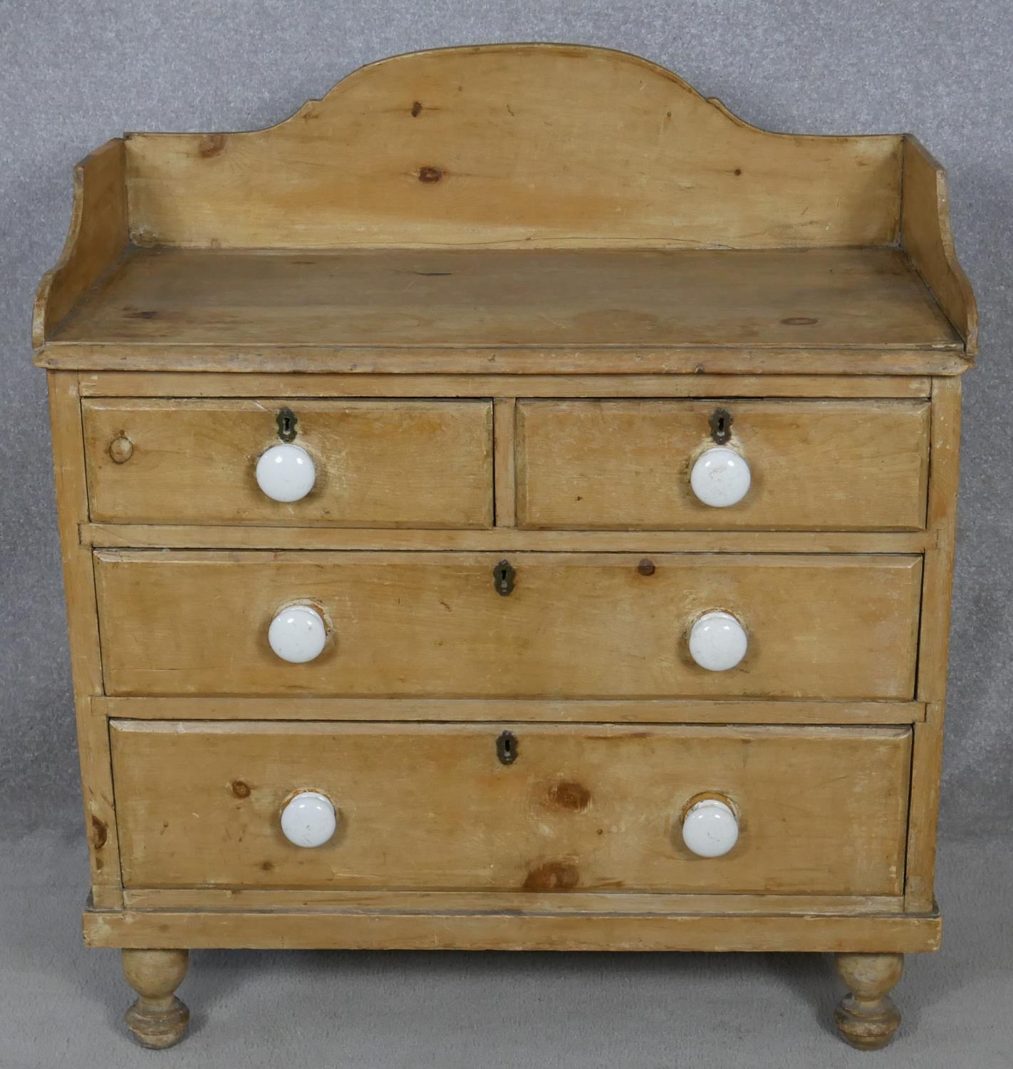 A Victorian pine chest with galleried back and porcelain handles on turned supports. H.97 W.85.5 D.