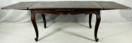 A C.1900 French oak draw leaf extending dining table with parquetry inlaid top raised on carved