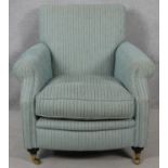 A contemporary 19th century style upholstered armchair on turned mahogany bun supports terminating