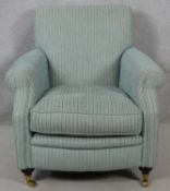A contemporary 19th century style upholstered armchair on turned mahogany bun supports terminating