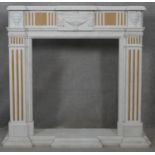 A Classical style marble fire surround and hearth with carved urn decoration to the frieze flanked
