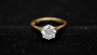 An 18 carat yellow gold and diamond solitaire ring. Set to centre with a round brilliant cut diamond