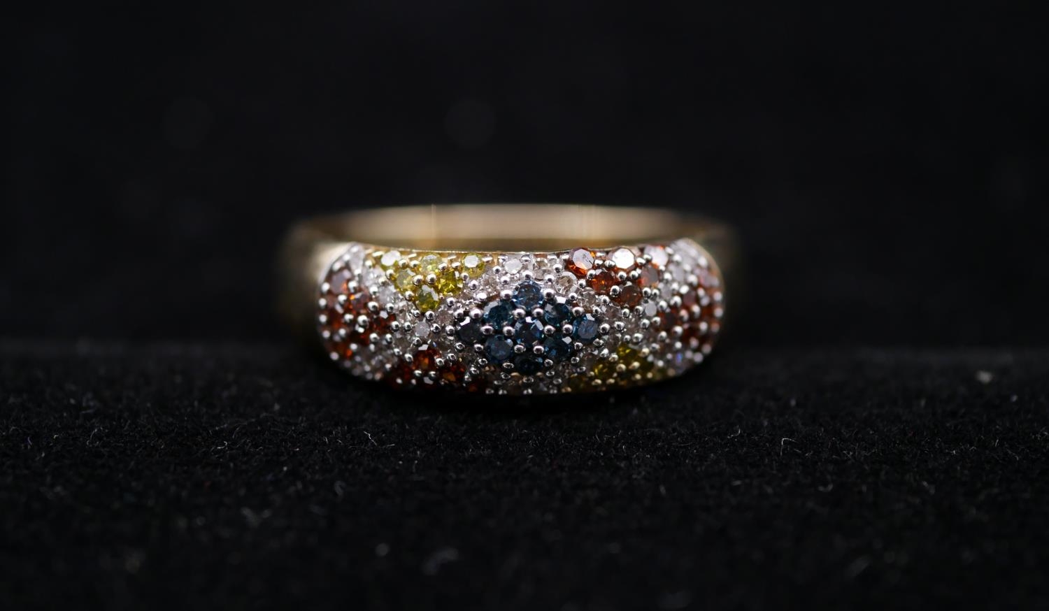 A 9 carat yellow gold and coloured diamond half eternity ring. Set to centre with nine round