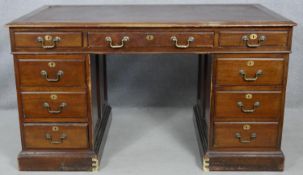 An early 20th century mahogany three section pedestal desk with maker's plaque to the inside and