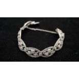 An Art Deco marcasite set silver pierced floral design articulated bracelet with push clasp and