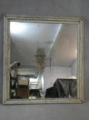 A wall mirror with original plate in distressed painted frame. 130x122