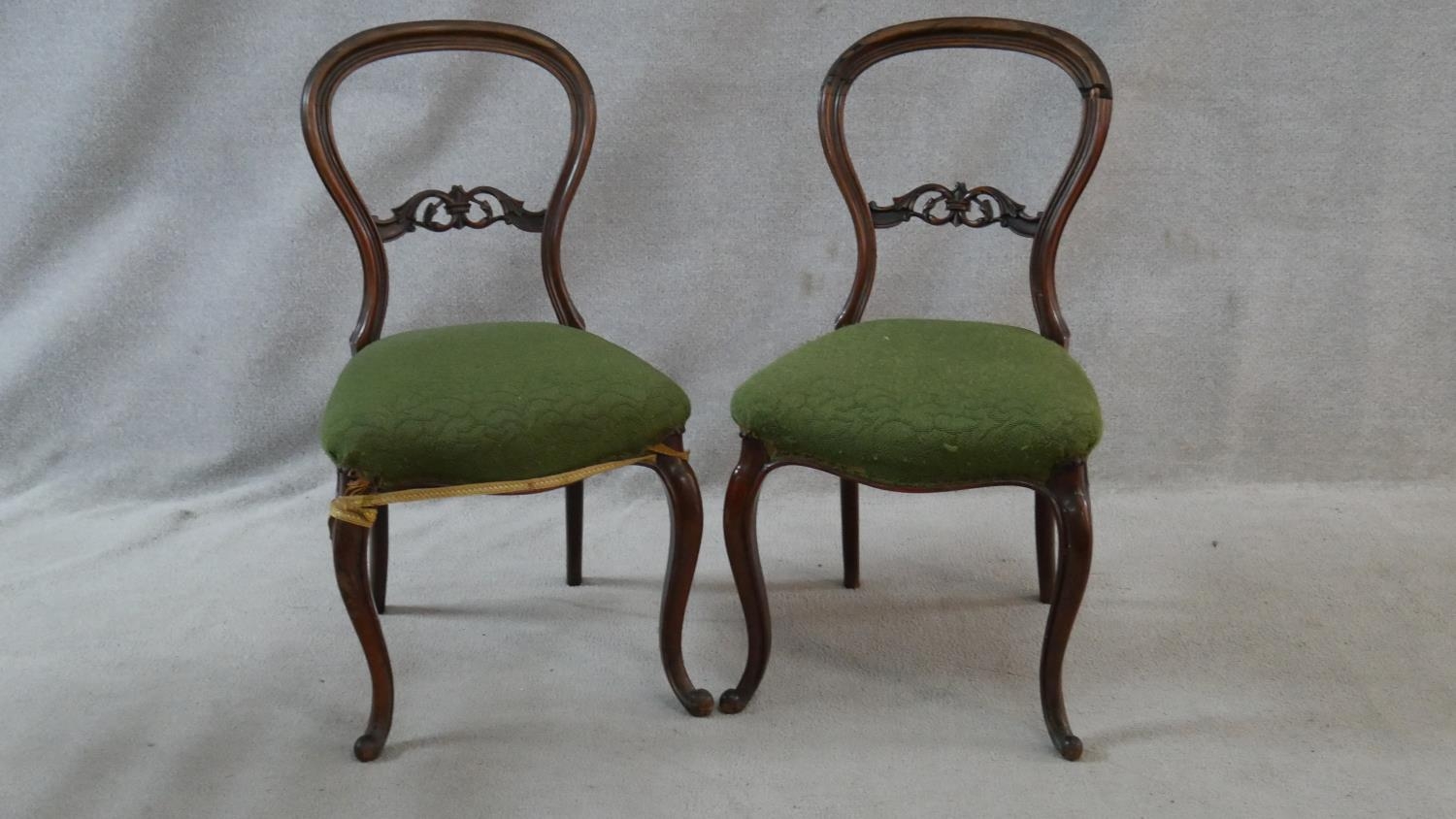 A pair of Victorian carved mahogany balloon back dining chairs on cabriole supports. H.88cm (damaged