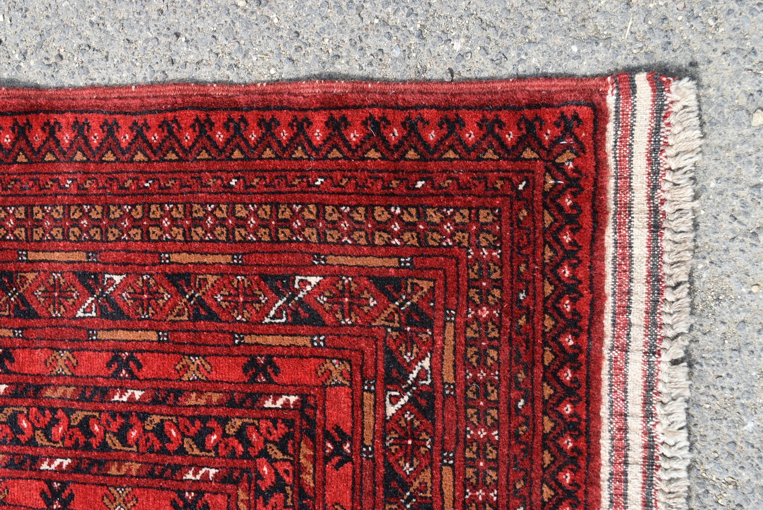 An Afghan Bokhara carpet with repeating gul motifs across the madder field enclosed by geometric - Image 3 of 4