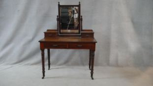 A 19th century walnut dressing table with swing mirror above a pair of frieze drawers on turned