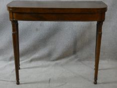 A 19th century mahogany and satinwood strung foldover top tea table on turned tapering supports. H.