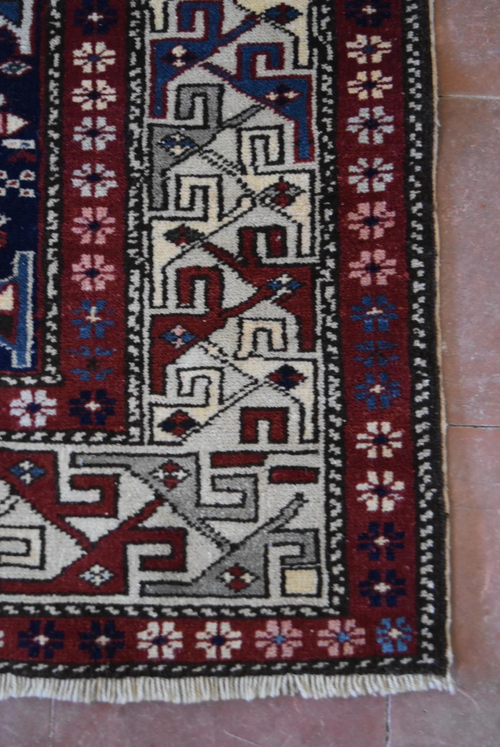 A fine Kazak style rug with double central medallions on indigo field with stylised animal and - Image 3 of 3