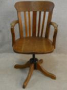 A late 19th century oak captain's desk armchair with swivelling and tilting action on quadruped