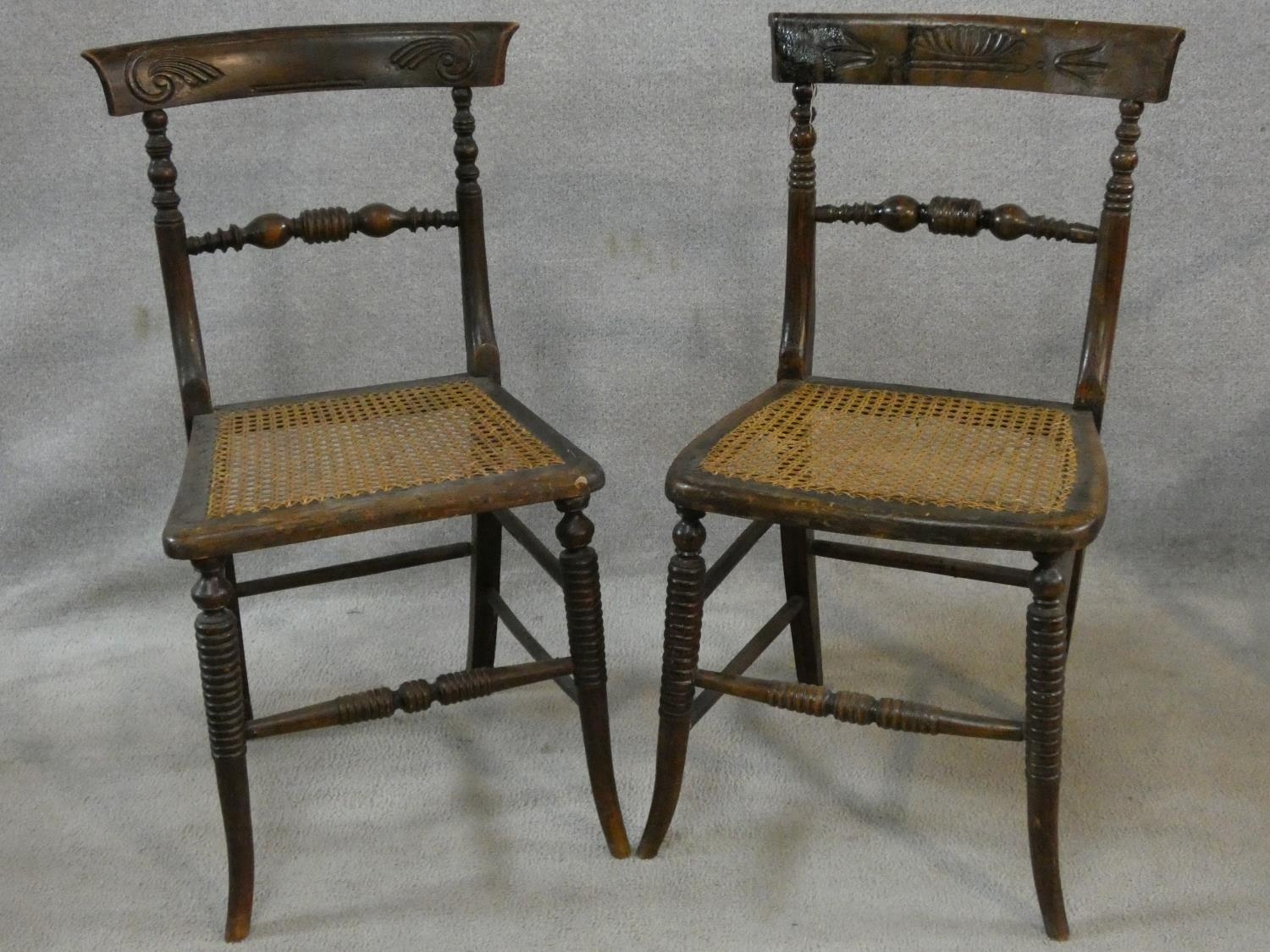 A pair of Regency faux rosewood bedroom chairs each with complementary carved back rails on ring
