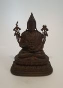 An antique Tibetan bronze buddha statue sitting on a lotus flower. H.26xW.18.5cm