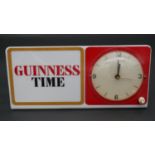 A mid century vintage electric advertising clock with backlight that displays "Guiness Time". H.14