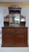 A late 19th century walnut sideboard with carved and mirror backed superstructure above drawers