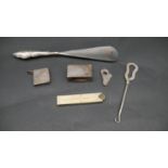 A collection of silver items. Including a silver handled shoe horn, an ivory and brass measure