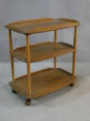 A mid century blonde elm Ercol three tier trolley on casters. H.75 L.72 W.46cm