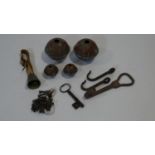 A collection of metalwork items including a bunch of antique iron keys, copper bells, three iron