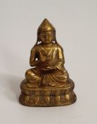 A 19th century Tibetan gilded bronze buddha, sitting on a lotus flower. H.9xW.13cm