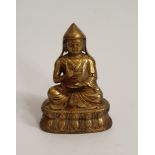 A 19th century Tibetan gilded bronze buddha, sitting on a lotus flower. H.9xW.13cm