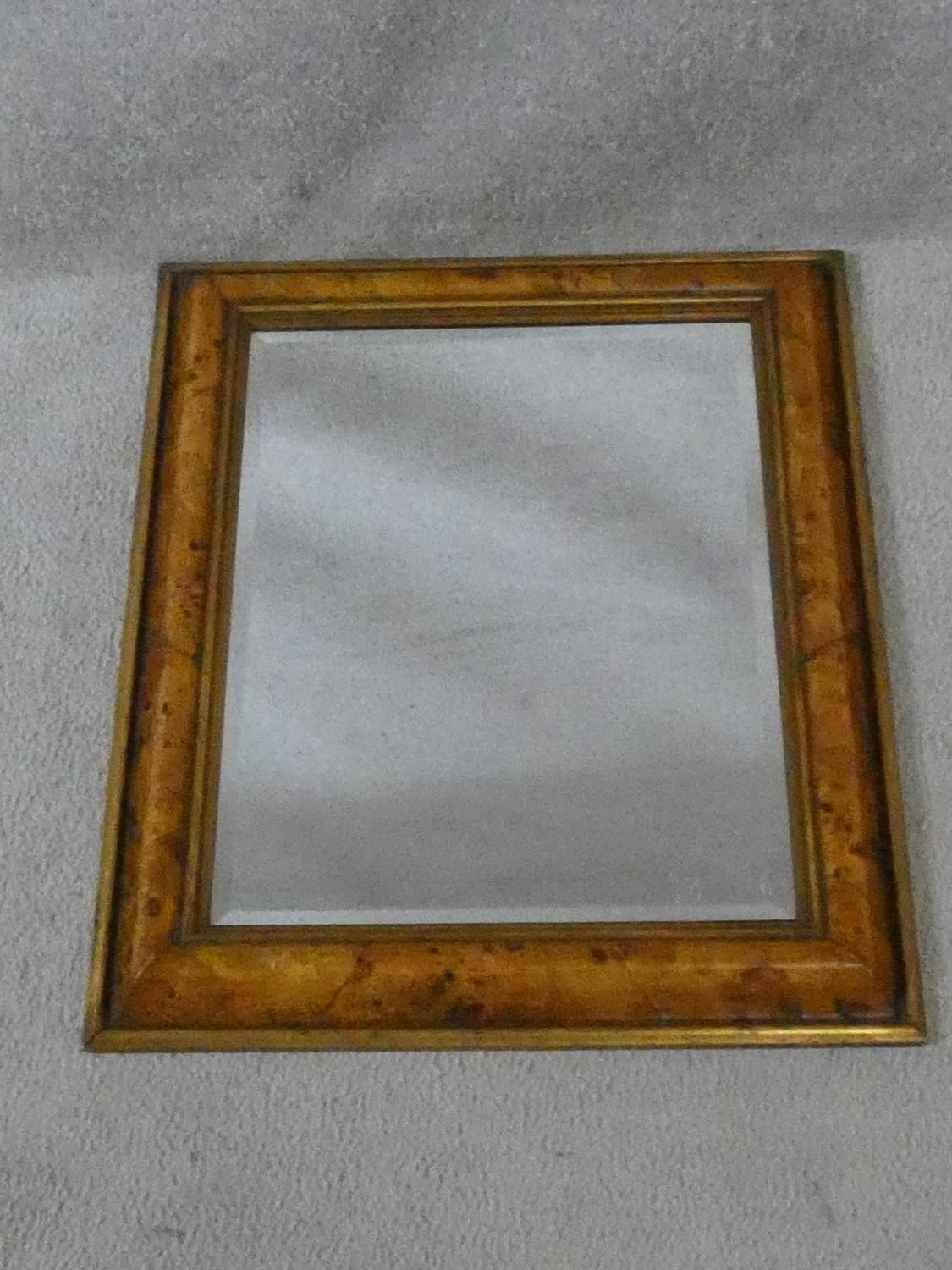 A bevelled wall mirror in burr elm moulded frame. H.58 W.48cm