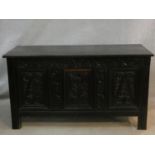 An antique country oak coffer with hinged lid above floral carved panels on block feet. H.75 L.136
