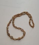 An ancient graduated agate, mother of pearl and alabaster bead necklace with gilt metal knot