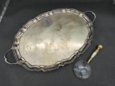 A large twin handled silver plated serving tray with scalloped ridge edges and foliate form feet