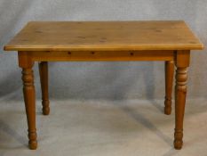 A Victorian style pine kitchen dining table on turned tapering legs. H.74 L.120 W.80cm