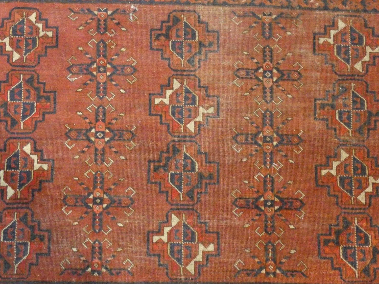 A Shirvan rug with repeating gul motifs across the madder ground contained by multiple stylised - Image 2 of 4