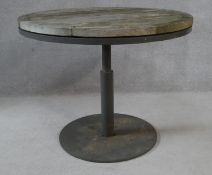 A weathered teak garden table on metal pedestal base. H.73 D.91.5cm